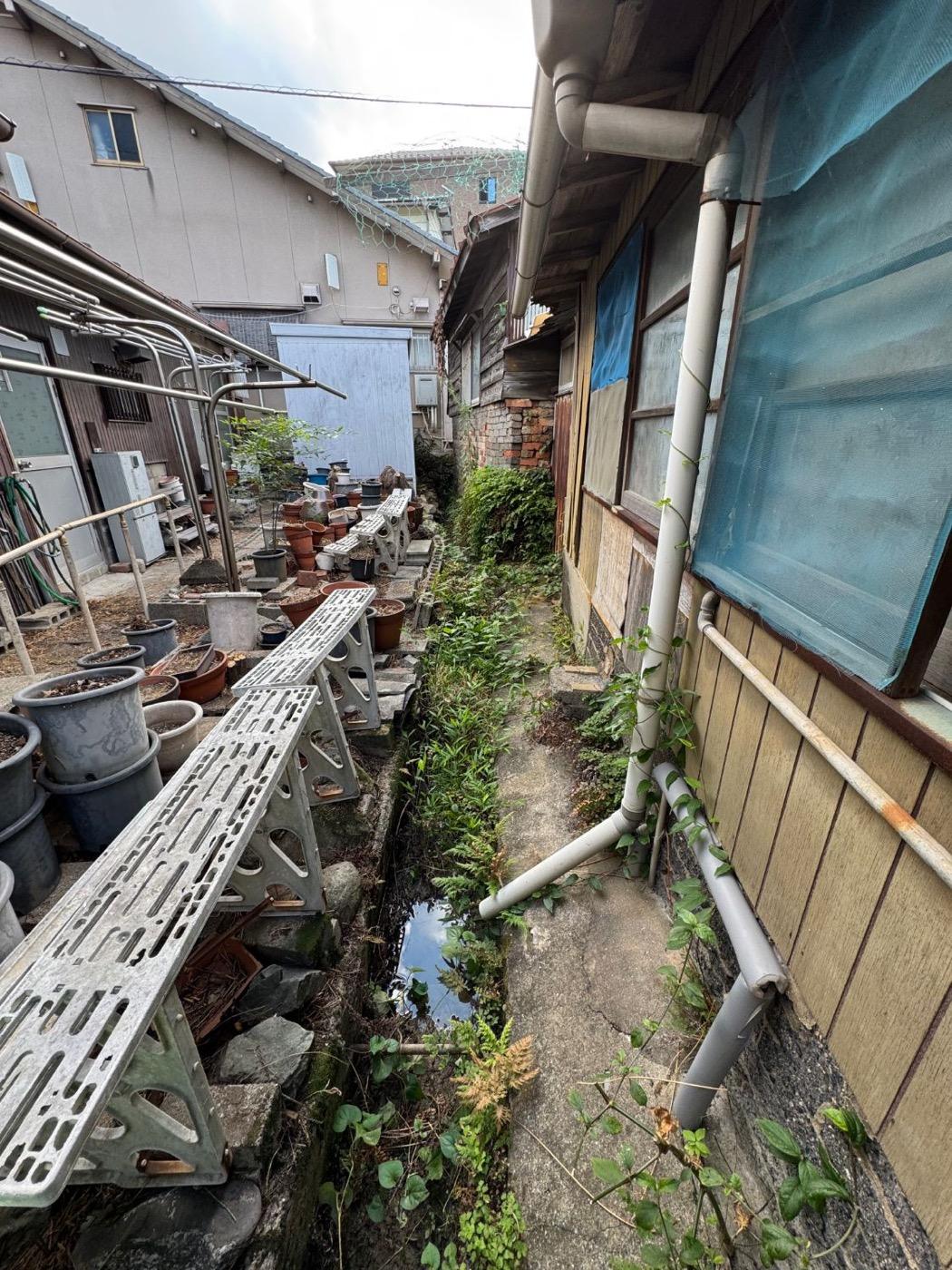 作業前：鉢や資材のわきの側溝にたまった泥と草を取り、流れを回復